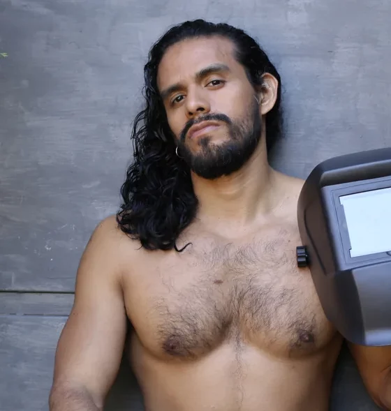 long hair man holding welding helmet