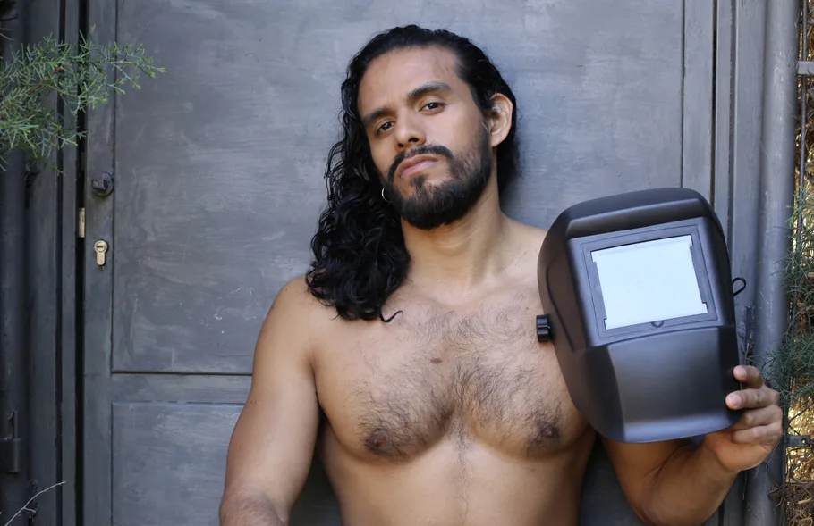 long hair man holding welding helmet