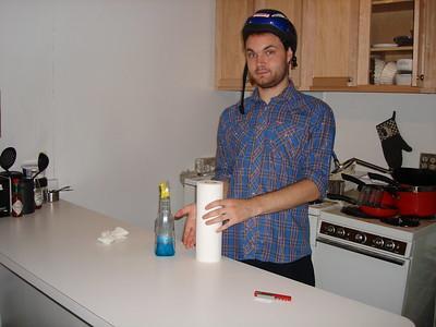 A person cleaning getting prepared to clean his used white countertop space with a kitchen cleaner.