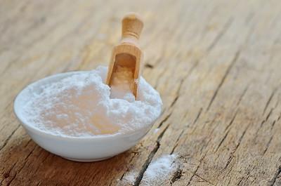 A white bowl of baking soda used in cleaning the kitchen exhaust hood.