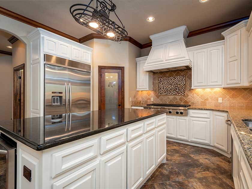 dark slate countertop in a kitchen with white contrasts and peach walls.