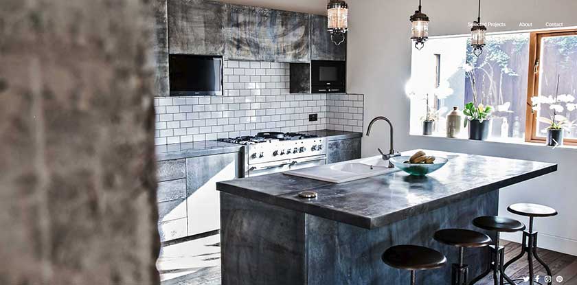 Zinc countertop for your kitchen in grey color with contrast of wite tiles on the wall and flowers in the window.