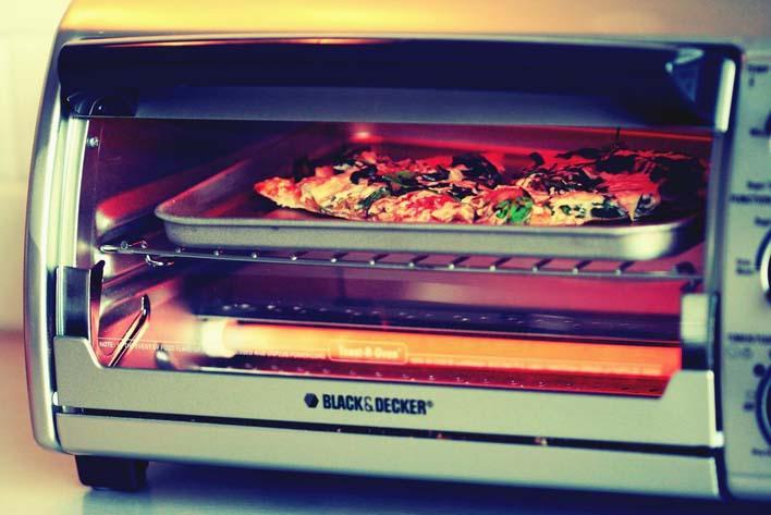 A toaster oven of silver color with a transparent glass door is a great small kitchen appliance.