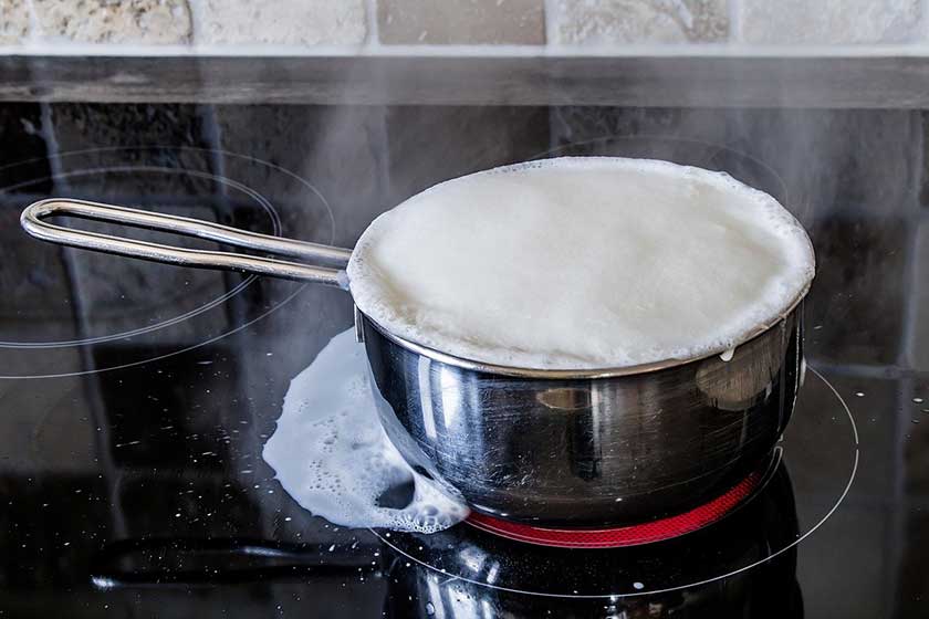 milk spilling over a ceramic hob