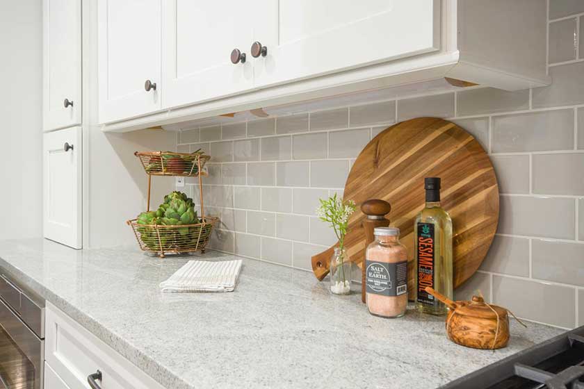 laminated chining on the kitchen countertop with some veggetables and glass jar on top