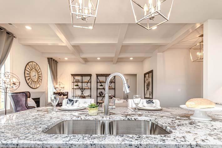 An open kitchen in a living room with a square shaped countertop installed on one side.