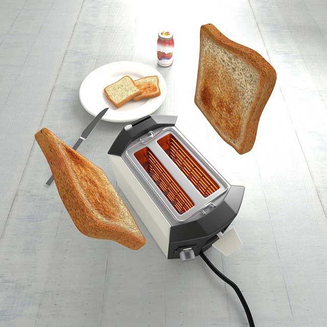 silver toaster with golden brown slices in mid air above the toaster.