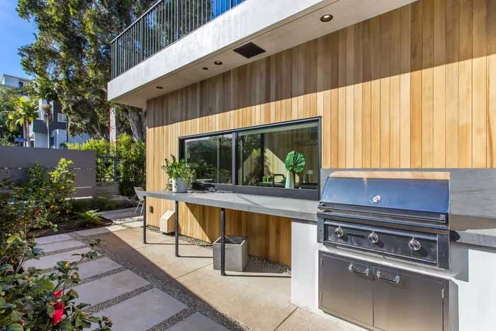 outdoor kitchen with grill and wood walls