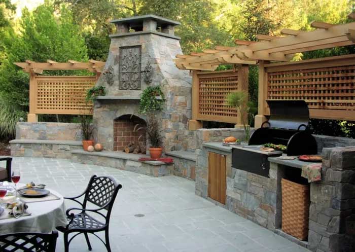 backyard of a house with green plants and dining table chair set in front